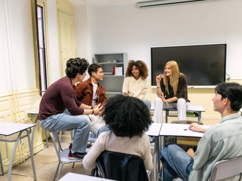 A group of students sitting at desks and chatting