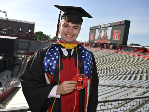 First-generation graduate Justin Morris (RBS ’26) stands in SHI Stadium before 260th anniversary Commencement for Rutgers University–New Brunswick and Rutgers Health class of 2026.