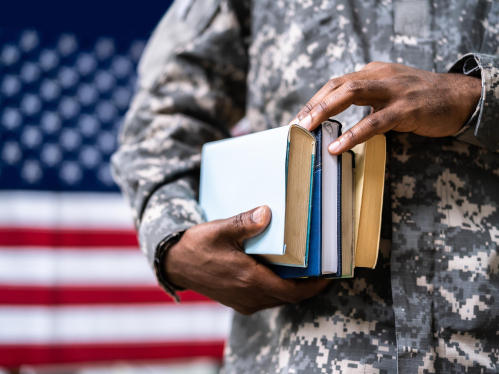 A military veteran holding school books