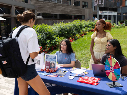 A student talks with Tesia Yachimovicz (second from left), Monica Dunkerson and Tania Saravanakumar at The Yard.