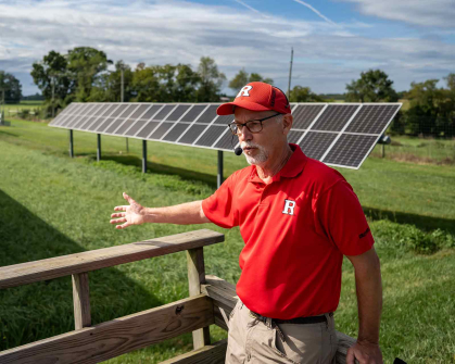 Before a field of hay and solar panels Peter Nitzsche describes an agrivoltaics project.