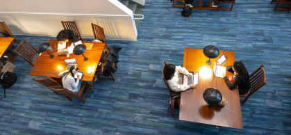 two tables with students seated in a library setting