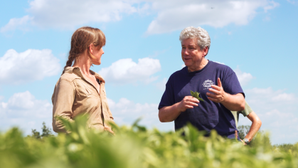 Rutgers Distinguished Professor Jim Simon standing in a field with farmer Jess Niederer of Chickadee Creek Farm.