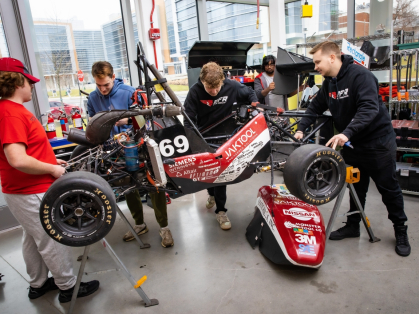 Engineering students work on a Formula 1 vehicle
