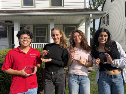 Four students standing in front of a house