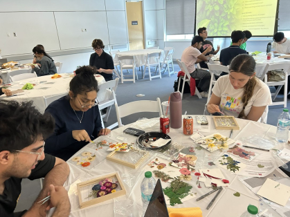 Groups of students sitting at round tables and working on craft projects