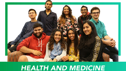 A group of students gathered with a green sign in front that reads Health and Medicine