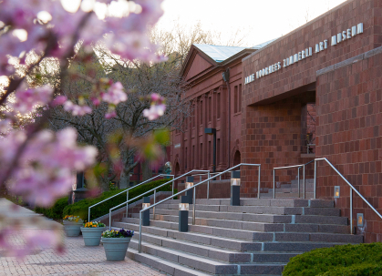 The stairs in front of the entrance of the Zimmerli Art Museum with flowers blurred in the foreground