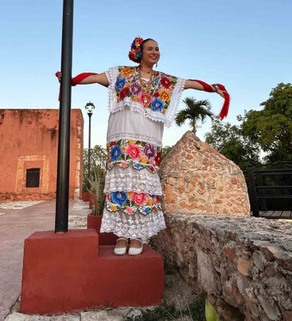 Alyssa McKendry – dressed in a terno, traditional formal attire in Yucatán – holds on to a light pole in the Mexican city of Tekax in May.