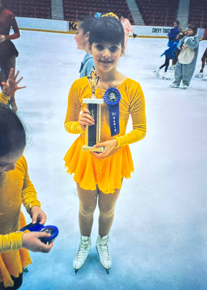A young Francine Glaser holds a first-place trophy and ribbon during a competition held in the Olympic ice rink in Lake Placid, N.Y.