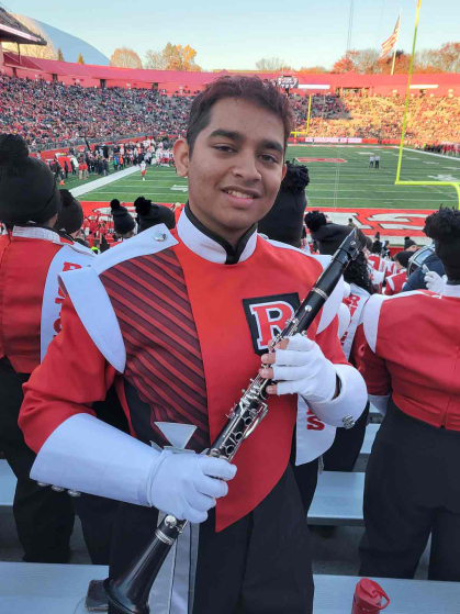 Mukhilan Saravanakumar, a member of the Rutgers University Marching Scarlet Knights, poses between performing at SHI Stadium.