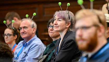 A group of scientists sit in an auditorium listening to speakers.