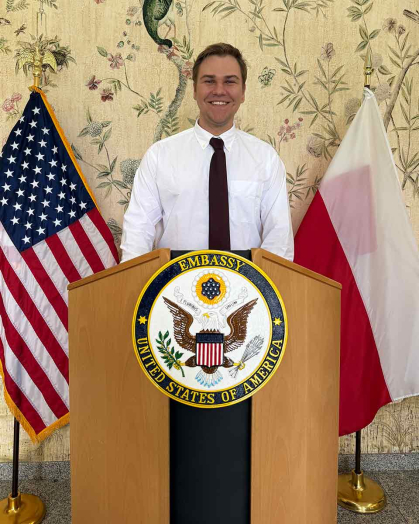 Christopher Slipiec speaks at the podium during a Fulbright graduation ceremony held at the Polish Chief of Mission's residence in Warsaw.