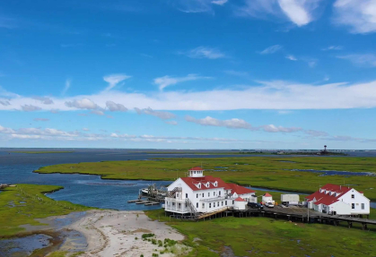 An aerial view of the Rutgers Marine Field Station - big blue sky, green marsh grass and blue water