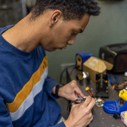 Mason Diaz works with soldering iron within the Rutgers School of Engineering.