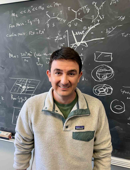 Nicolas Fernandez, a postdoctoral associate at Rutgers-New Brunswick, stands before a chalkboard marked with equations and sketches.