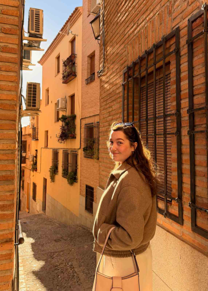 Rutgers graduate Victoria Richard walks down a stony flight of stairs on a narrow city street in Spain.