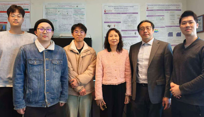 Six people in a lab stand together for a photo
