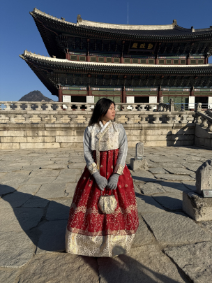 Pauline Kung standing in front of Gyeongbokgung Palace in Hanbok while on a study abroad trip to South Korea.