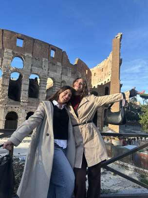 A study abroad student, Kamilla Tala​​ and friend, posing in front of the Colosseum in Italy.