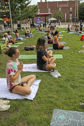Students engaged in a yoga class outside at The Yard