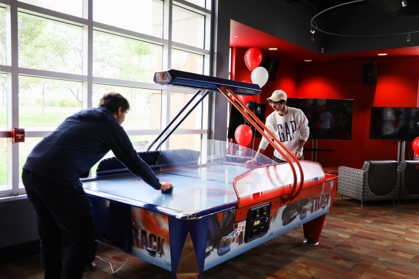 Two students playing air hockey at The Rutgers Zone