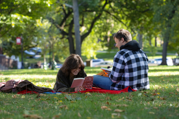Jamie Oliver (SAS ’26) and Christopher U Bolhuis (SAS ’25) study on the lawn of at Voorhees Mall on College Ave campus on a fall day.
