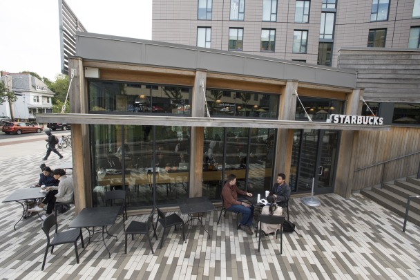 Students sitting at tables outside Starbucks on College Avenue