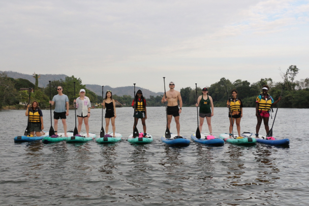 Students paddle boarding on the River Kwai in Thailand