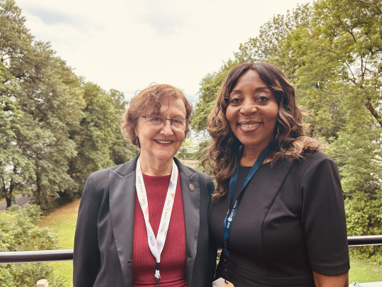 Eva Andrea and Chancellor Conway in front of scenery with trees