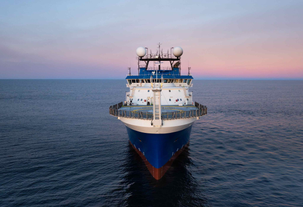 Research vessel facing the camera head on, with bow in front.