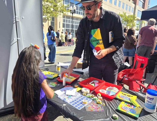 Jeremiah William McCarthy (right), the Zimmerli's chief curator, engages with a young girl during the 2025 New Brunswick Heart Festival.