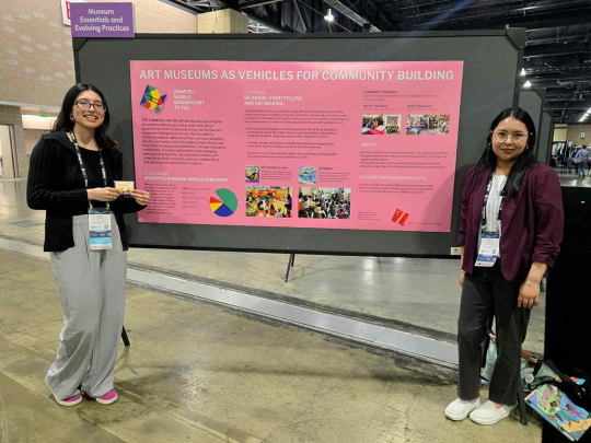 Hanna Cherres (left) and Jessie Garci hold up a poster during the American Alliance of Museums Annual Meeting in May.