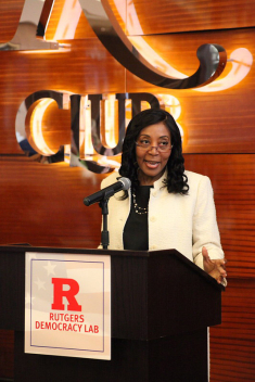 Chancellor Francine Conway speaks at a podium for a Rutgers Democracy Lab event
